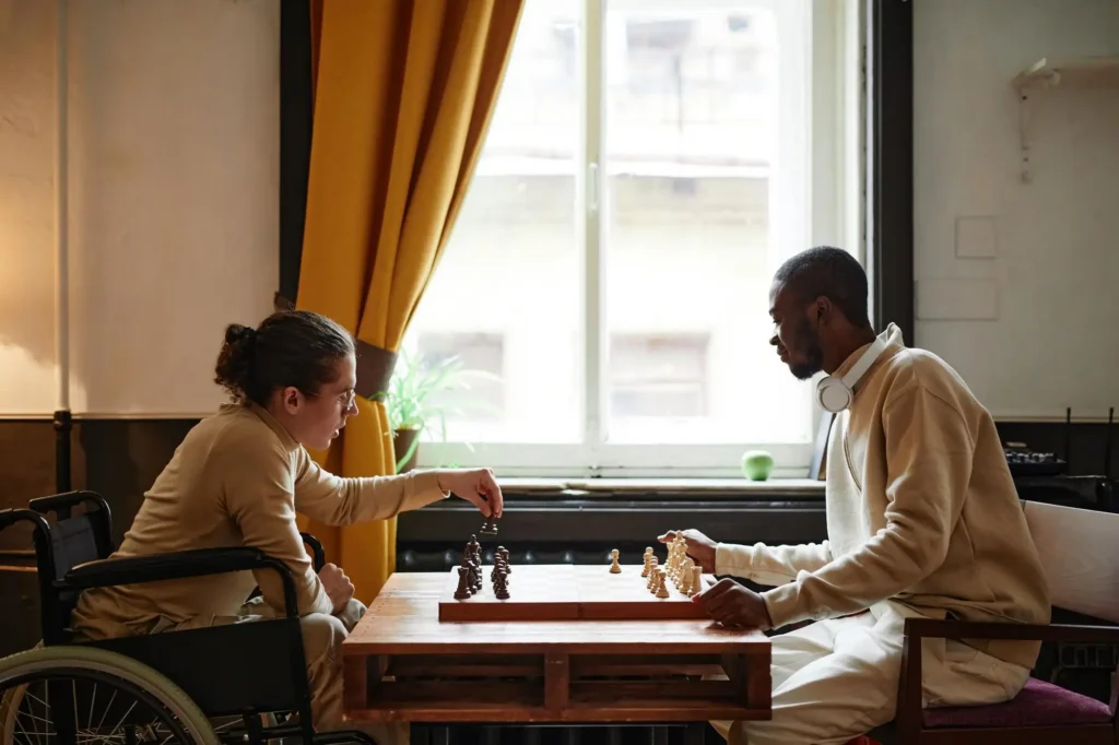 african-man-playing-chess-together-with-his-friend-with-disability-they-sitting-room