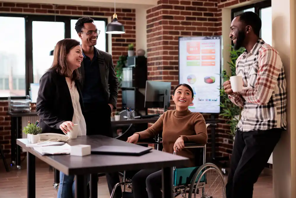 asian-woman-wheelchair-group-people-laughing-job-break-having-fun-disability-friendly-office-worker-with-chronic-health-condition-chatting-with-cheerful-colleagues